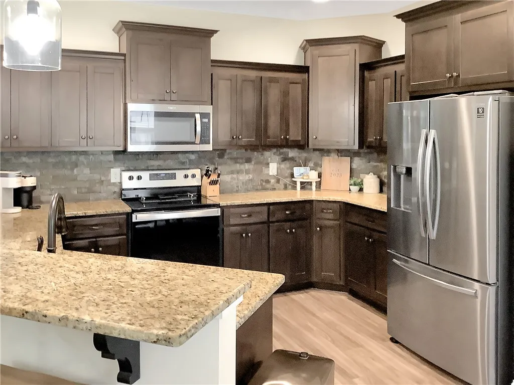 Culinary aspirations come alive in this meticulously appointed kitchen featuring rich cabinetry and luminous countertops.