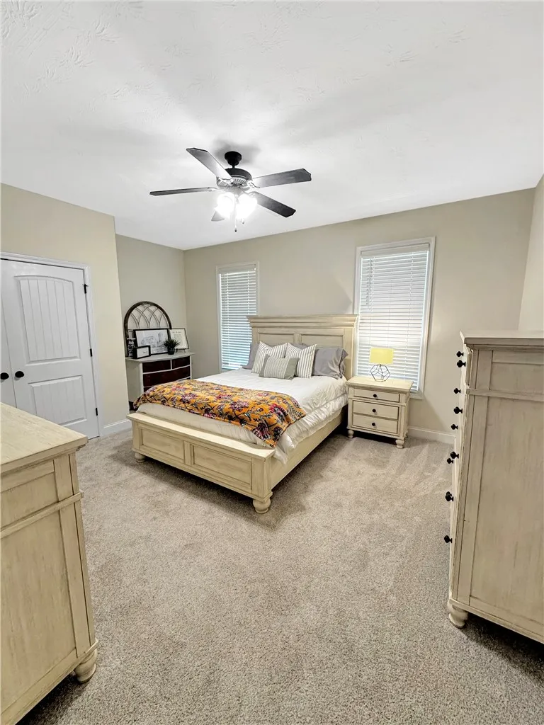 Plush carpeting and large windows enhance this comfortable and inviting primary bedroom.