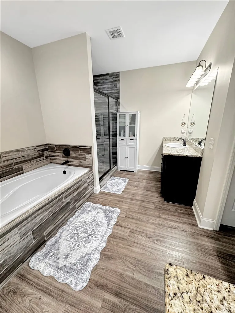 Relax in the deep soaking tub or refresh in the sleek walk-in shower of this private bathroom.
