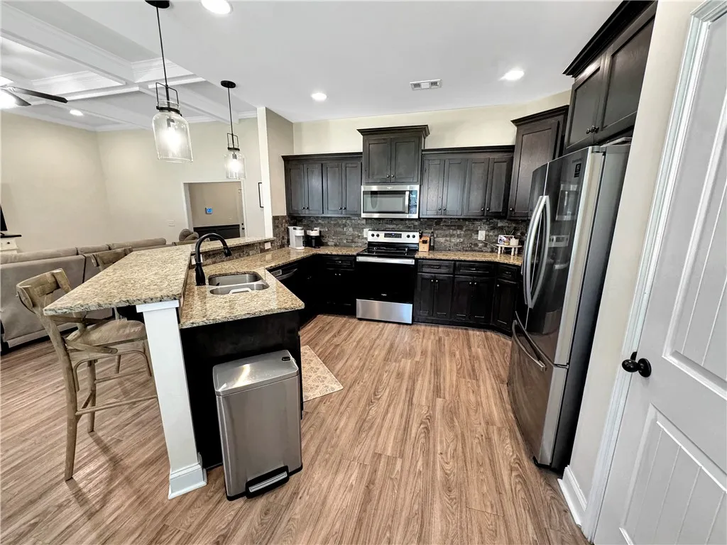 A well-appointed culinary space featuring granite counters and durable flooring.