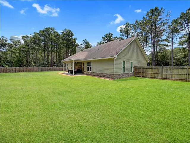 A spacious backyard with a covered patio offers ample room for outdoor activities.