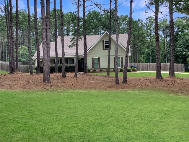 A private estate with a tranquil yard, surrounded by mature trees and verdant landscaping.