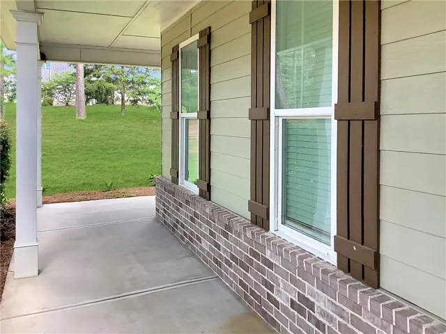 A welcoming covered porch with a durable concrete surface extends an invitation to outdoor living.