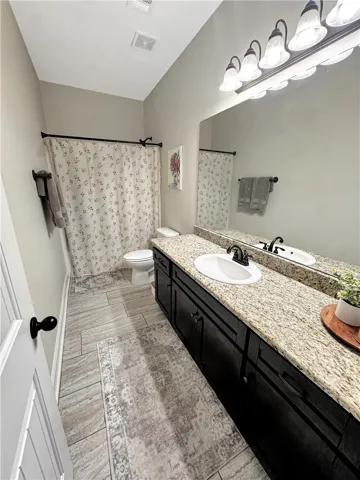 Granite counters and wood cabinetry create a well-appointed primary bath.