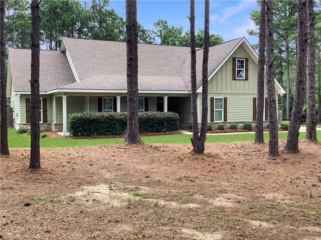 A classic exterior with wood siding and a welcoming porch, nestled among mature trees.