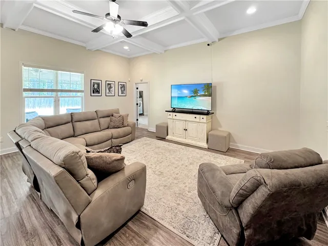 An inviting family room offers elevated coffered ceilings and rich hardwood flooring for relaxed gatherings.
