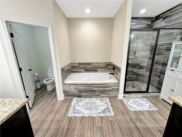 Relax and refresh in a modern primary bathroom featuring a spacious walk-in shower and a built-in soaking tub.