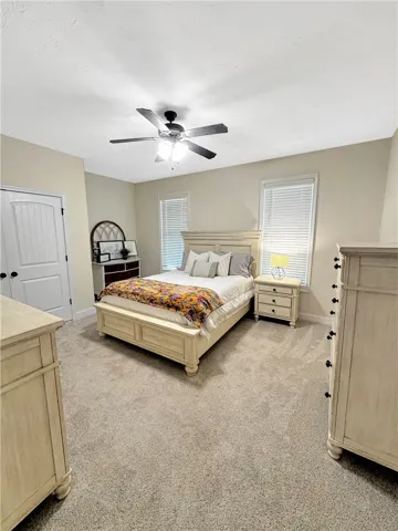Plush carpeting and large windows enhance this comfortable and inviting primary bedroom.