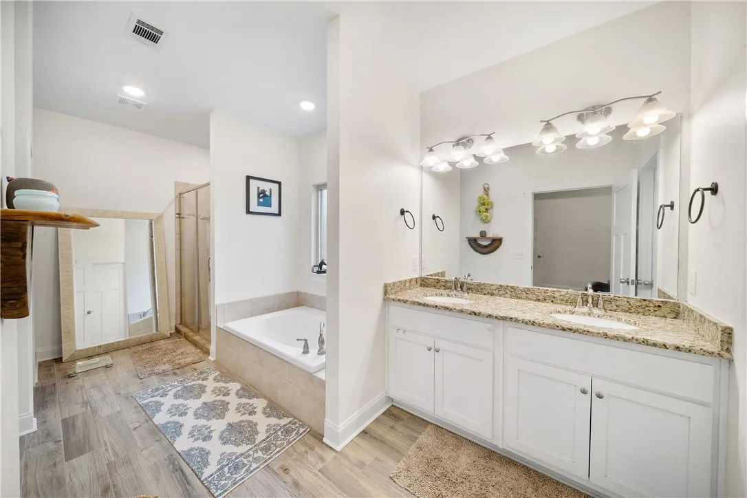 Indulge in a tranquil primary bathroom featuring a spacious dual vanity and a built-in tub.