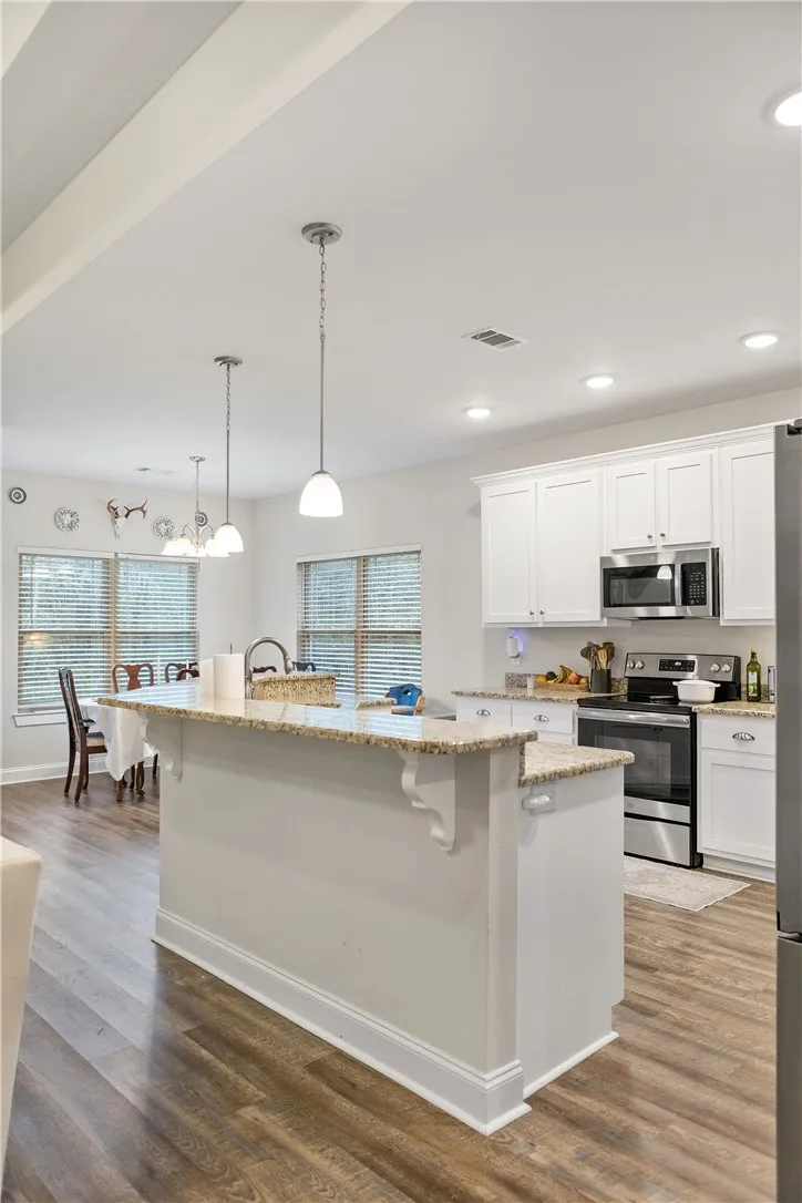 A well-appointed kitchen island with gleaming countertops overlooks the dining area.