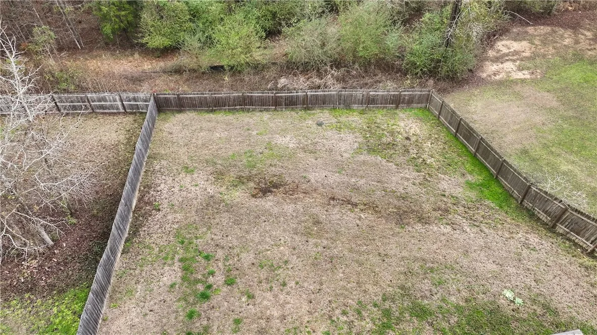 A spacious backyard enclosed by a durable wood fence, offering ample room for outdoor activities.