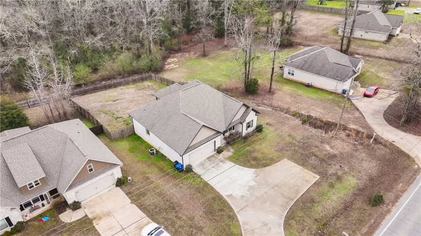 An aerial perspective reveals the residential layout, where homes meet natural woodlands.