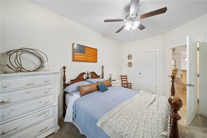 A comforting bedroom space featuring soft carpeting and a classic ceiling fan for ultimate comfort.