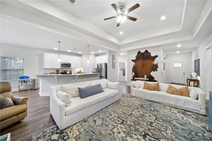 An open concept living area boasts a kitchen with an island, a great room, and high ceilings.