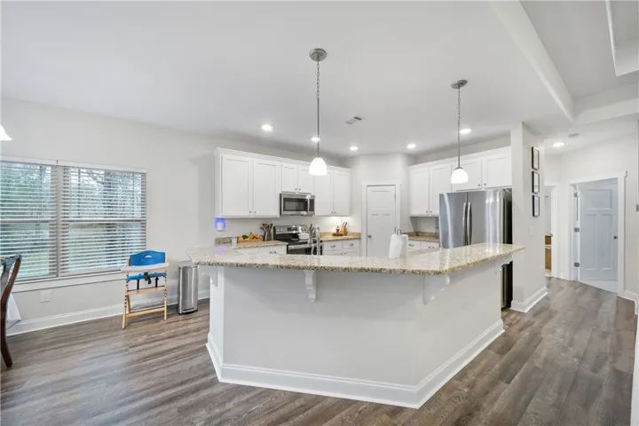 A luminous culinary space with abundant counter seating and sleek, modern finishes.