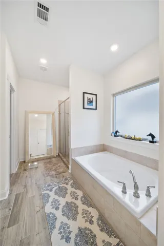 Indulge in a tranquil bathing experience with this spacious soaking tub and adjacent shower.