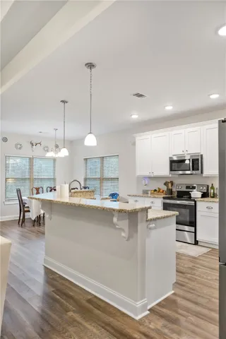 A well-appointed kitchen island with gleaming countertops overlooks the dining area.