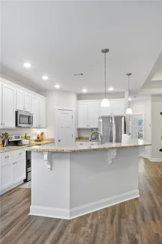 Culinary creations come to life in this contemporary kitchen, boasting granite countertops and rich hardwood flooring.