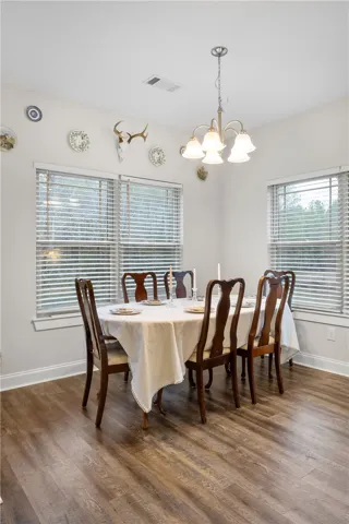 A traditional dining area with rich wood flooring and natural light, perfect for gatherings.