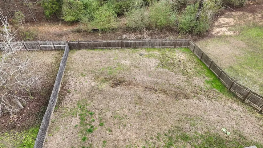A spacious backyard enclosed by a durable wood fence, offering ample room for outdoor activities.