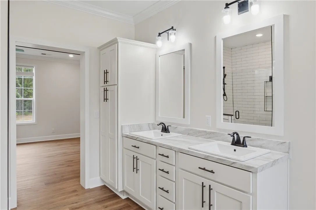 Marble countertops and a dual vanity offer refined elegance in this bright bathroom.