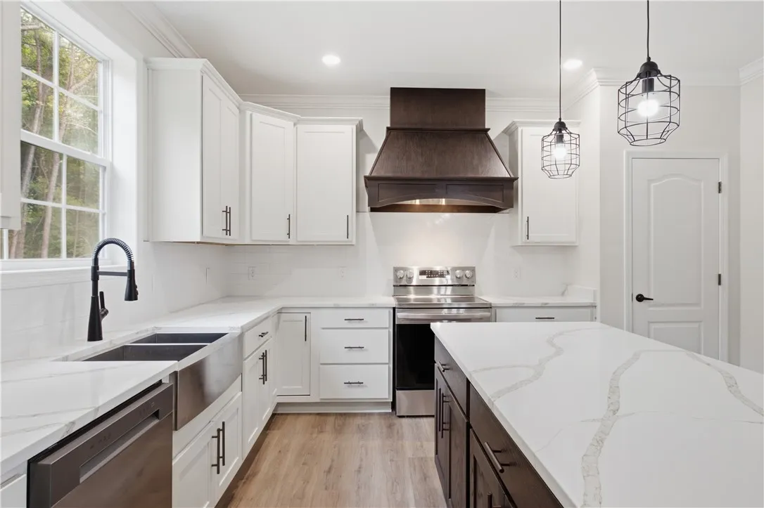 A well-appointed kitchen features white cabinetry, a large island, and modern stainless steel appliances.