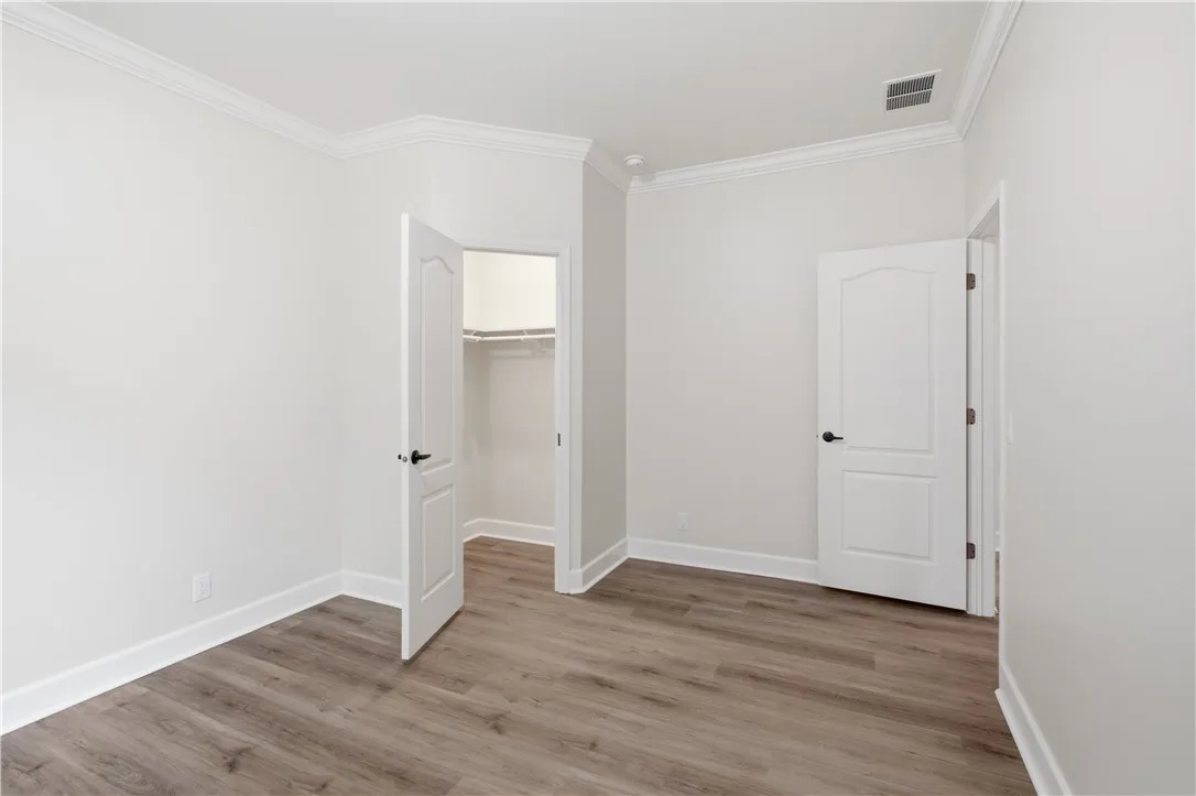A well-proportioned room showcasing crown molding, fresh paint, and durable wood-look flooring.