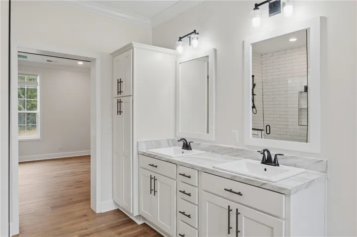 Marble countertops and a dual vanity offer refined elegance in this bright bathroom.