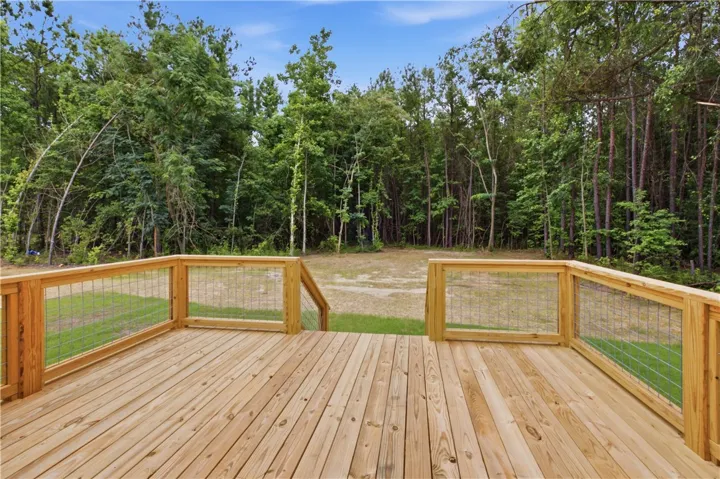 A spacious wooden deck provides tranquil views of the private, wooded backyard.