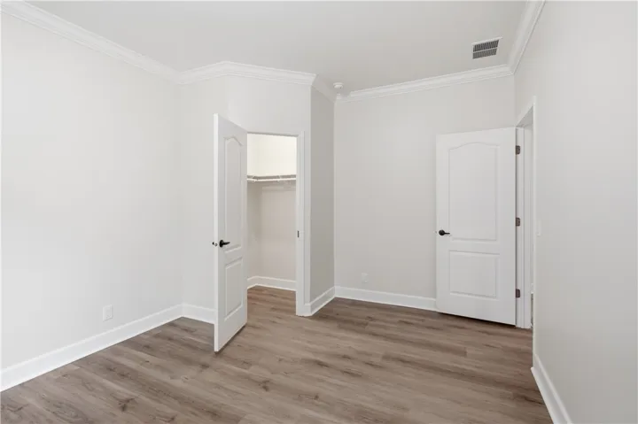 A well-proportioned room showcasing crown molding, fresh paint, and durable wood-look flooring.