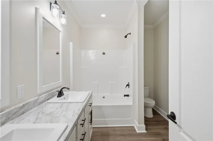 A well-appointed bath features a double vanity and a shower-tub combination.