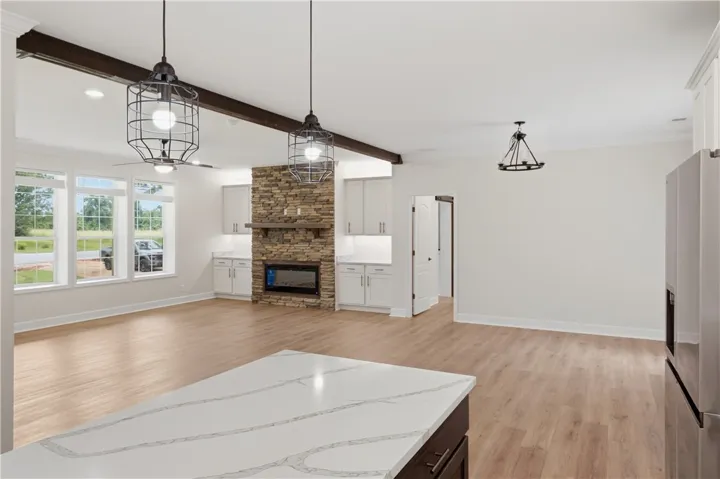 An open concept living area presents abundant natural light and a captivating stone fireplace.