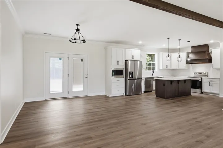 A spacious kitchen with white cabinetry and an island anchors this open-concept living area.