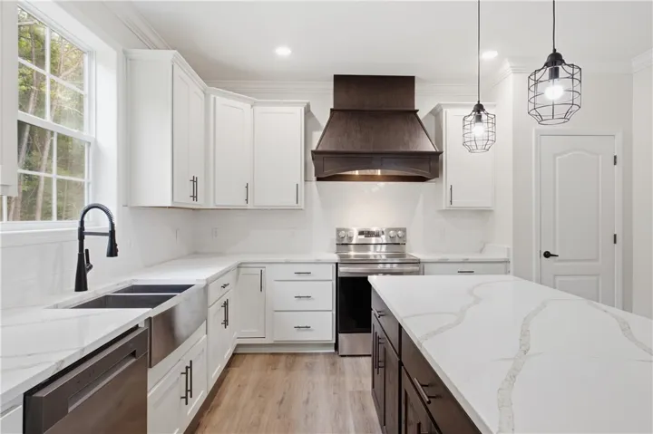 A well-appointed kitchen features white cabinetry, a large island, and modern stainless steel appliances.