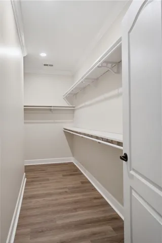 Ample shelving and hanging space in this well-organized walk-in closet with durable flooring.