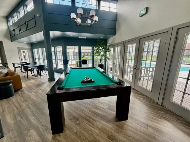 A spacious recreation room with a pool table and abundant natural light invites lively gatherings.