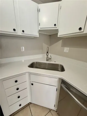 Functional kitchen with a gleaming stainless steel sink.
