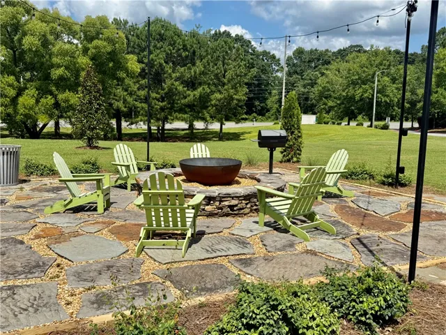 Gather around this inviting stone fire pit area, perfect for tranquil evenings under string lights.