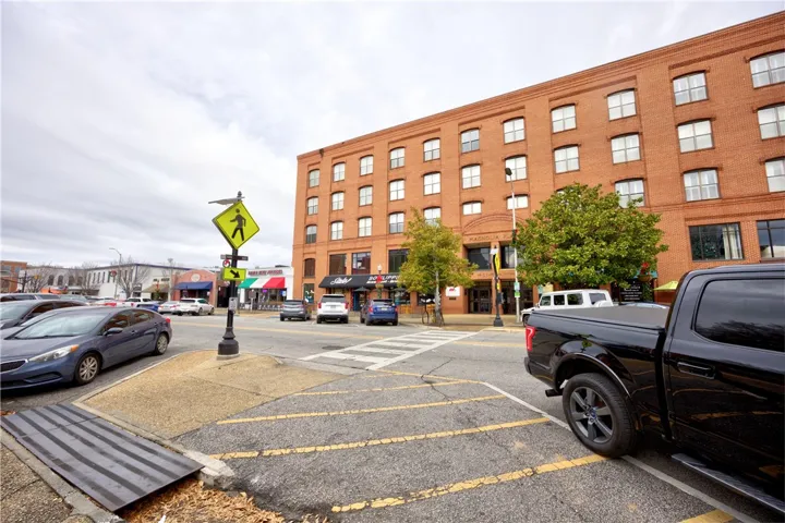 A classic brick building anchors this bustling urban street, offering convenience and a vibrant community.