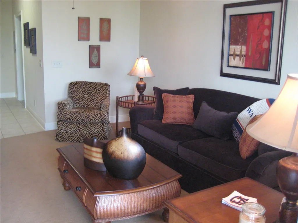 An inviting living area featuring plush carpeting and a hallway entrance.