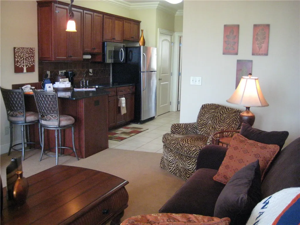 Rich wood cabinetry and a functional breakfast bar define this open-concept kitchen and living area.