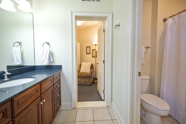 Granite counters and neutral tile flooring anchor this functional bathroom layout.