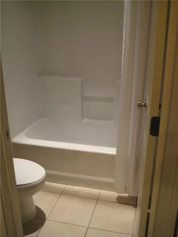 Tiled flooring and a tub/shower combination complete this well-maintained bathroom.