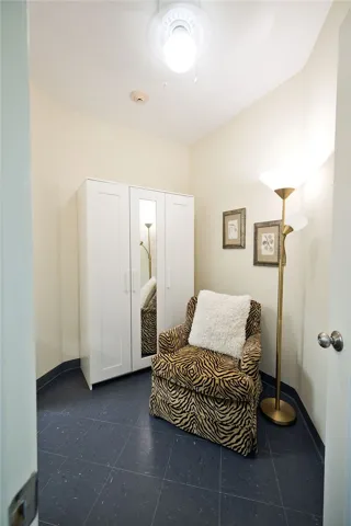 Dark tile flooring and neutral walls define this versatile dressing room or home office space.