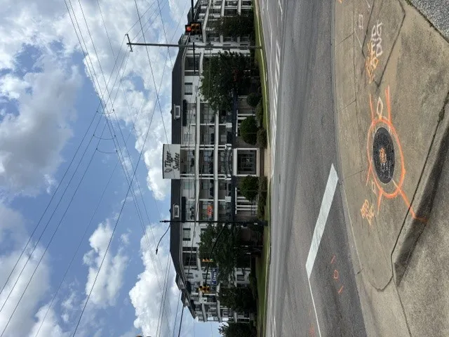 A dynamic street view captures a multi-story building and well-maintained public sidewalks.