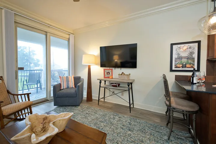 Crown molding and sliding glass doors leading to a private balcony define the living space.