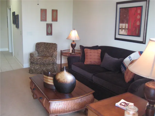 An inviting living area featuring plush carpeting and a hallway entrance.