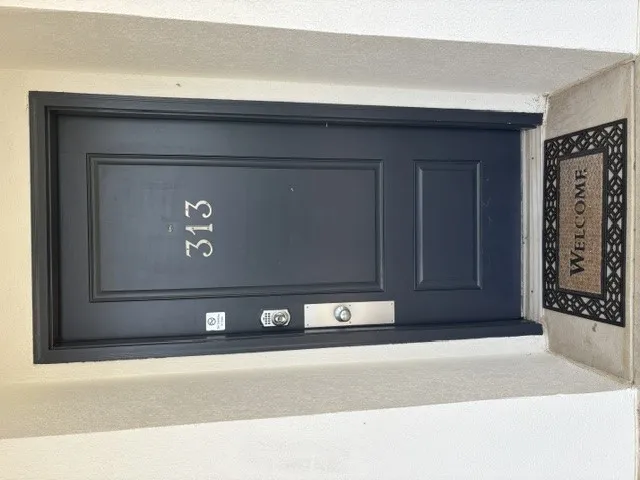 A dark, paneled entry door with house numbers awaits your arrival.