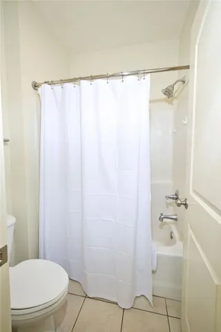 A classic tub and shower combination anchors this light-filled guest bath.