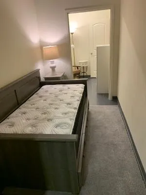 A versatile sleeping area with soft carpeting and convenient access to an adjacent room.